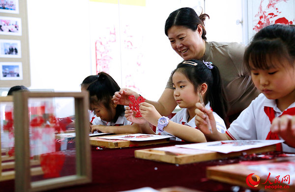 Inheritor Passes on Traditional Paper Cutting in N China's Tianjin